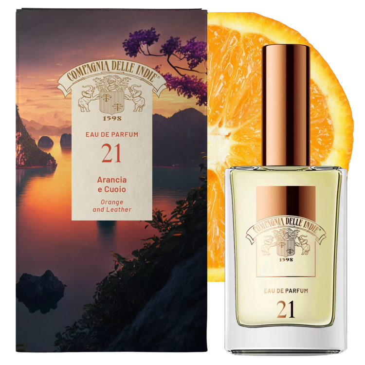 COMPAGNIA DELLE INDIE Eau de Parfum #21 Arancia e Cuoio - butelka z miedzianym atomizerem na tle opakowania i pokrojonej pomarańczy, widok trzech czwartych produktu.