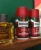 Proraso piana do golenia Barbe Dure czerwona 400ml - trzy opakowania na drewnianej półce z płynem po goleniu, widok z boku na tle zielonego tła.