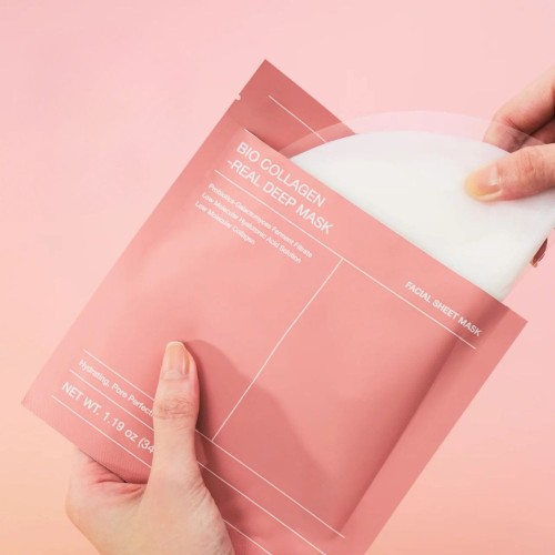 BioDance Bio Collagen Real Deep Mask maska w płachcie – różowe opakowanie trzymane w dłoniach, widok pełny produktu na różowym tle.