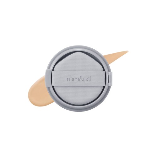 rom&amp;nd Nu Zero Cushion 04 Beige 23 - kryjący podkład w poduszce, szara kompaktowa puszka z aplikatorem, próbka koloru na białym tle.