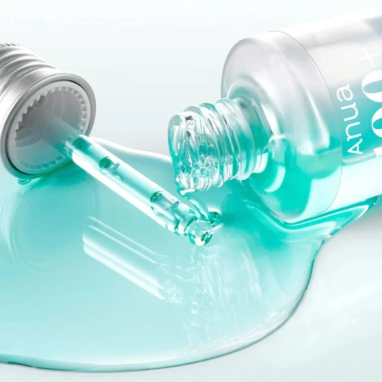 Anua 100+ PDRN + Hyaluron Serum - serum intensywnie odbudowujące, zblizenie na buteleczkę z turkusowym płynem wylewanym na szklane podłoże